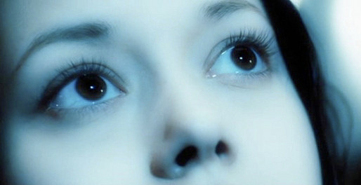 River Tam gazing up at a screen before whispering 'Miranda' in the film Serenity