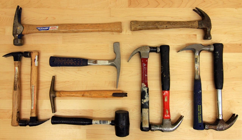 A number and variety of hammers on a table