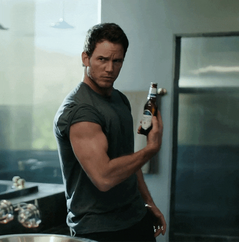 Chris Pratt feigning a bicep curl with a beer